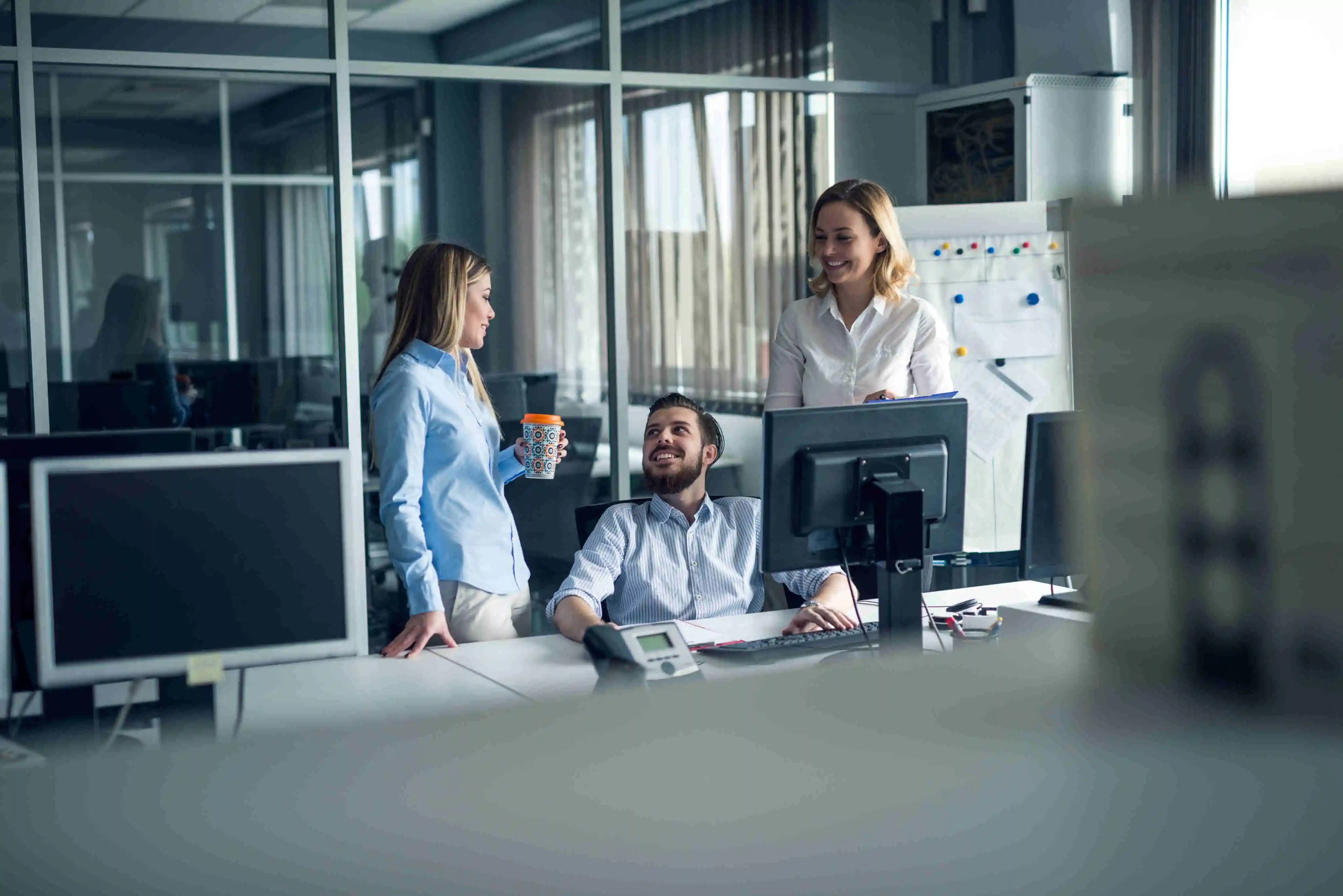 IT-Spezialisten, die in ihrer Arbeit vertieft sind, umgeben von Technologie in einem modernen Büro, wo Innovation auf Effizienz trifft.