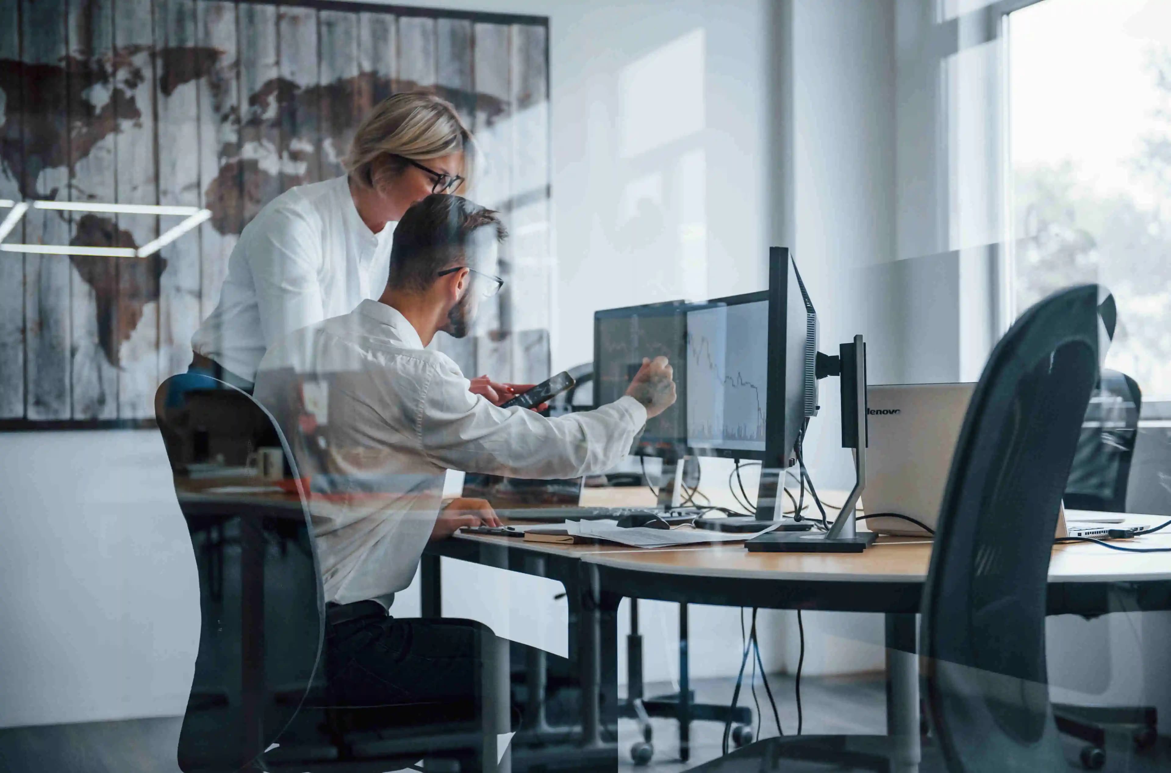 IT-Spezialisten, die in ihrer Arbeit vertieft sind, umgeben von Technologie in einem modernen Büro, wo Innovation auf Effizienz trifft.