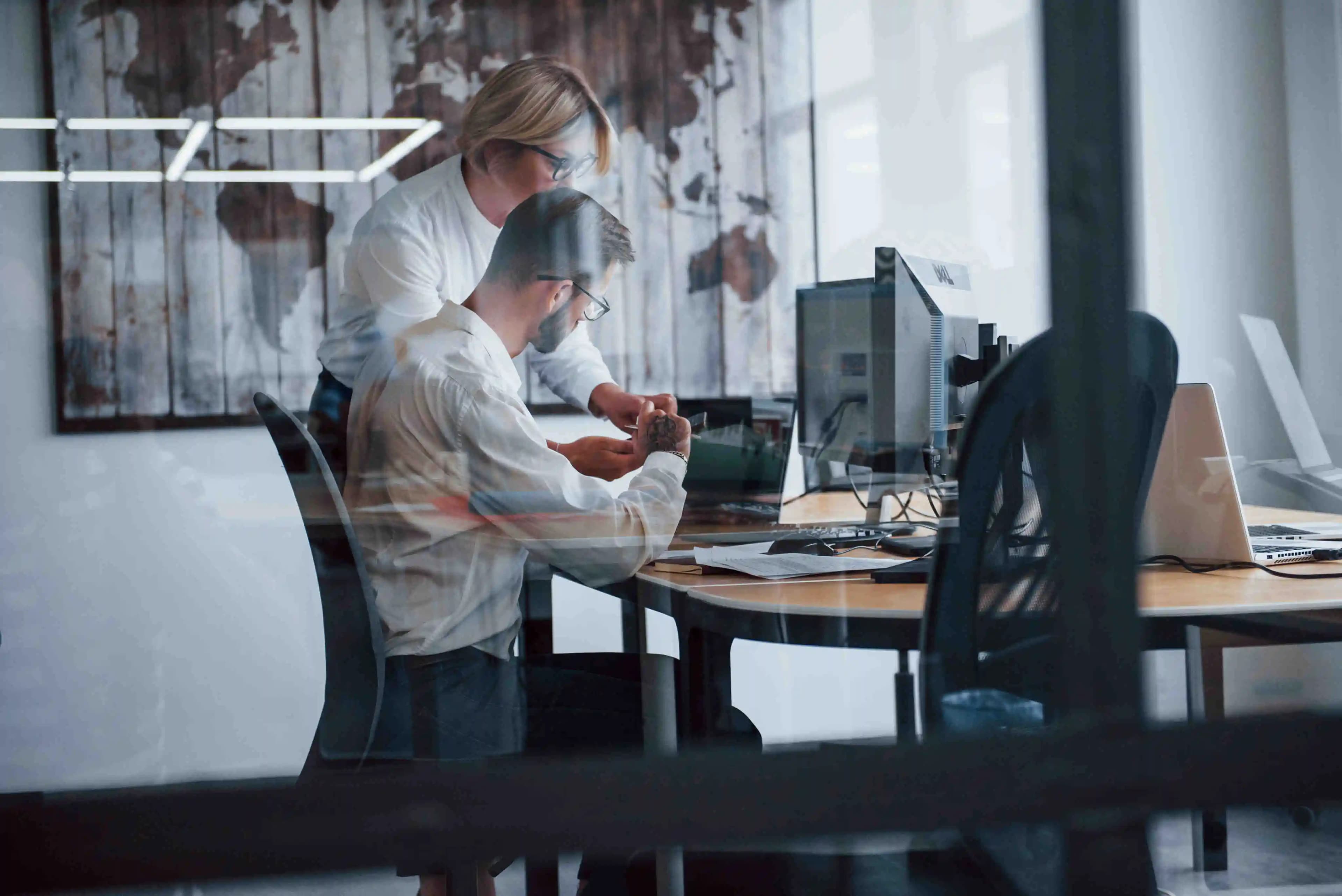 IT-Spezialisten, die in ihrer Arbeit vertieft sind, umgeben von Technologie in einem modernen Büro, wo Innovation auf Effizienz trifft.