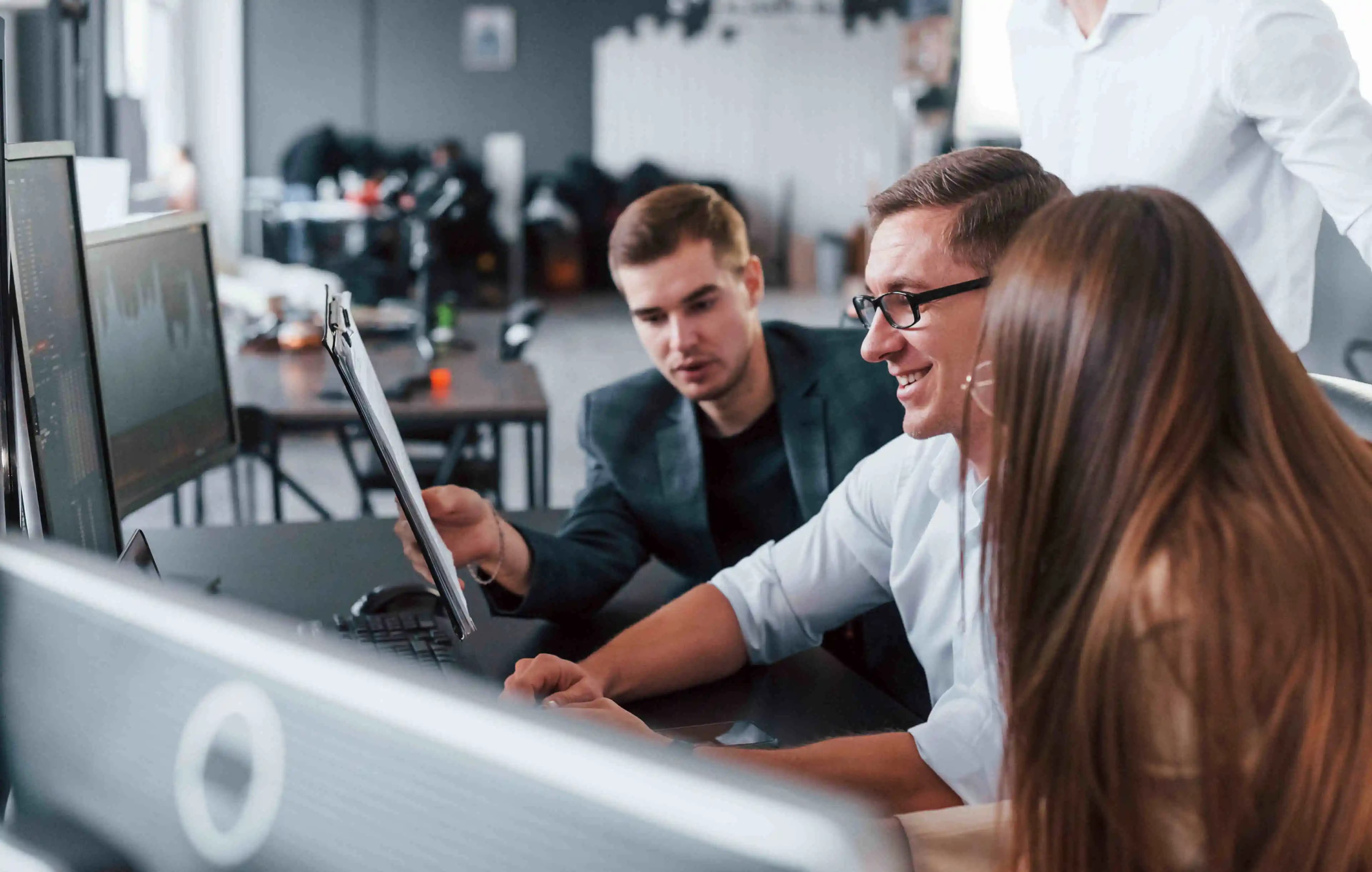 IT-Spezialisten, die in ihrer Arbeit vertieft sind, umgeben von Technologie in einem modernen Büro, wo Innovation auf Effizienz trifft.